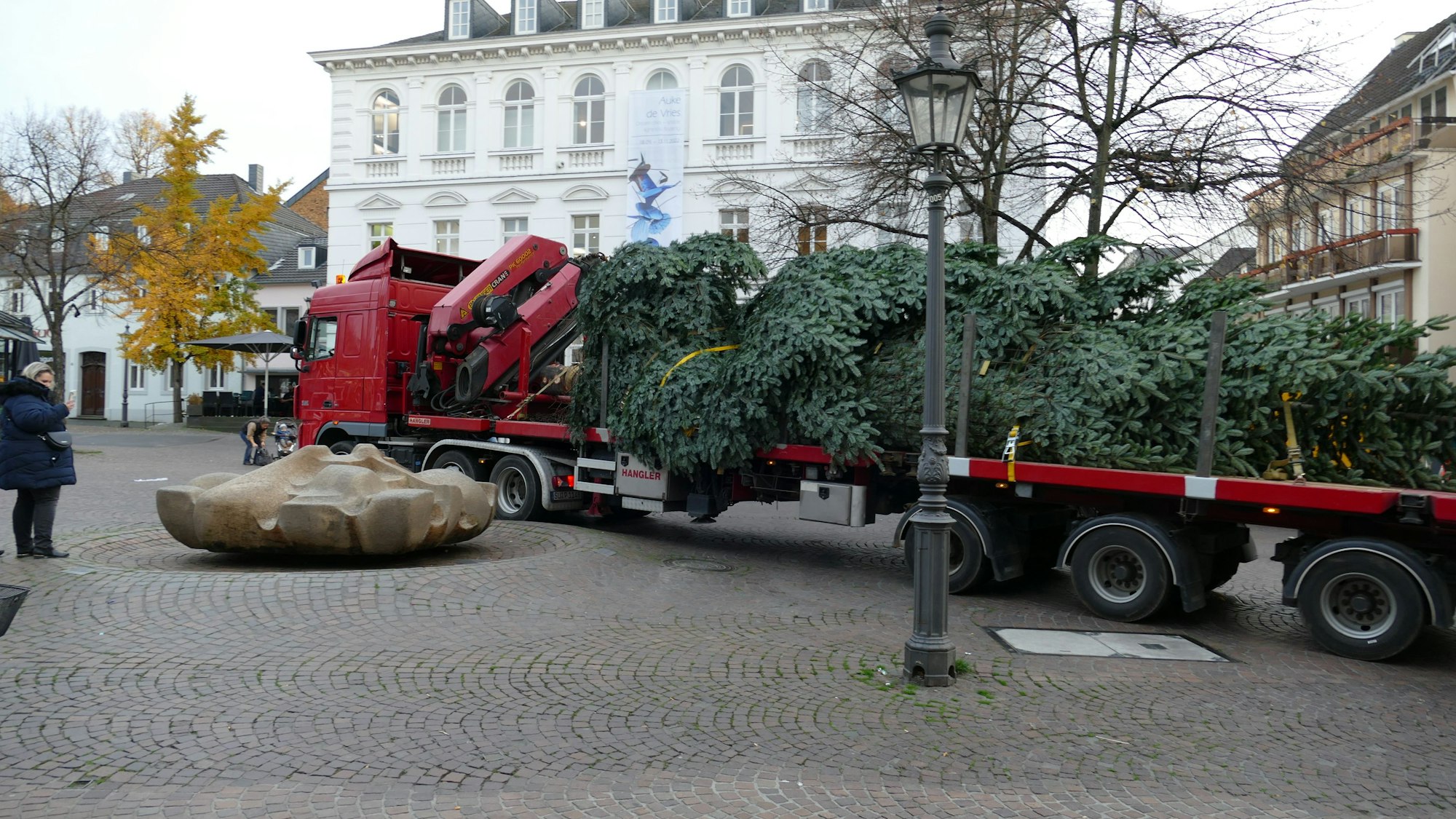 Auf einem Lkw liegt die 15 Meter lange Tanne. Der Lkw rollt auf den Marktplatz in Siegburg.