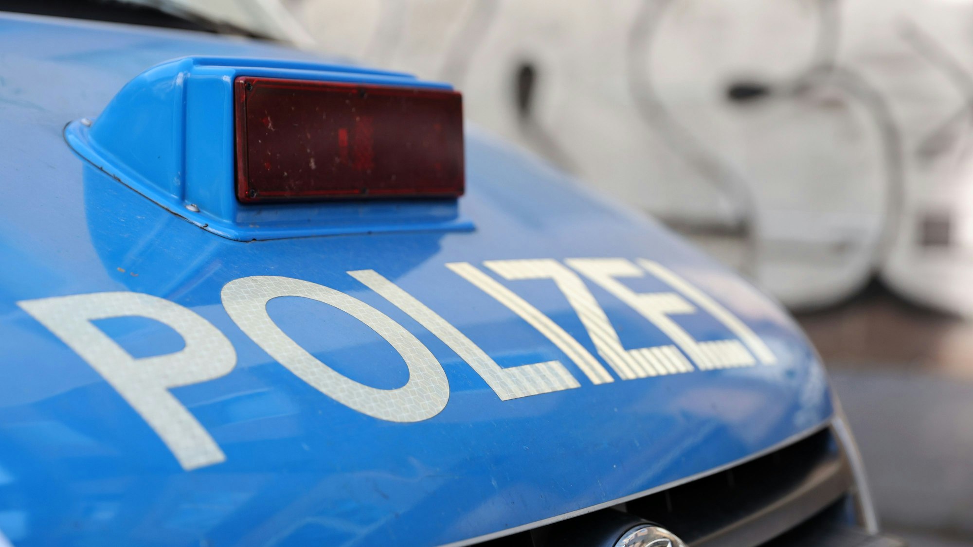 Die Aufschrift Polizei auf der Motorhaube eines Polizeiautos.