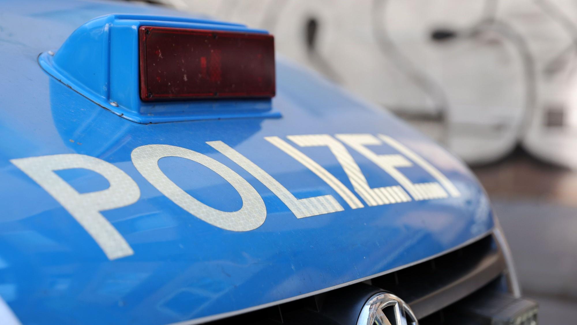Ein Polizeiauto mit der Aufschrift „Polizei“ in weiß auf der blauen Motorhaube.