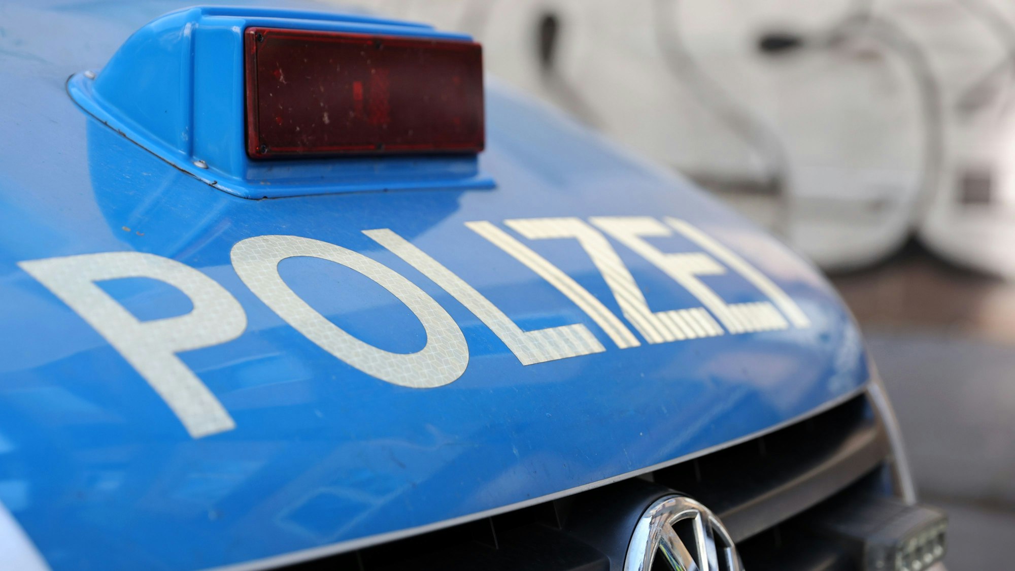 Blick auf den Polizei-Schriftzug auf einem Polizei-Wagen.