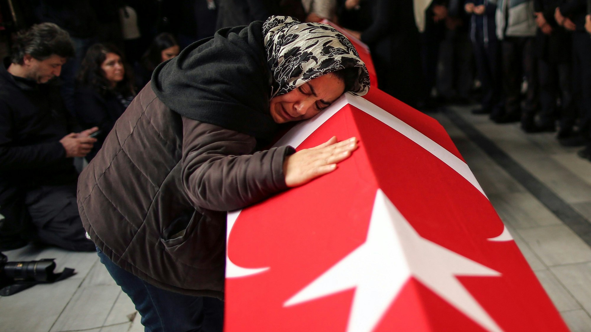 14.11.2022, Türkei, Istanbul: Eine Frau lehnt sich im Rahmen einer Beerdigung über den Sarg eines der Opfer des Anschlages.  Bei dem Anschlag am Sonntag, 13.11.2022, auf der belebten Einkaufsstraße Istiklal waren mehrere Menschen getötet worden und viele Weitere verletzt.