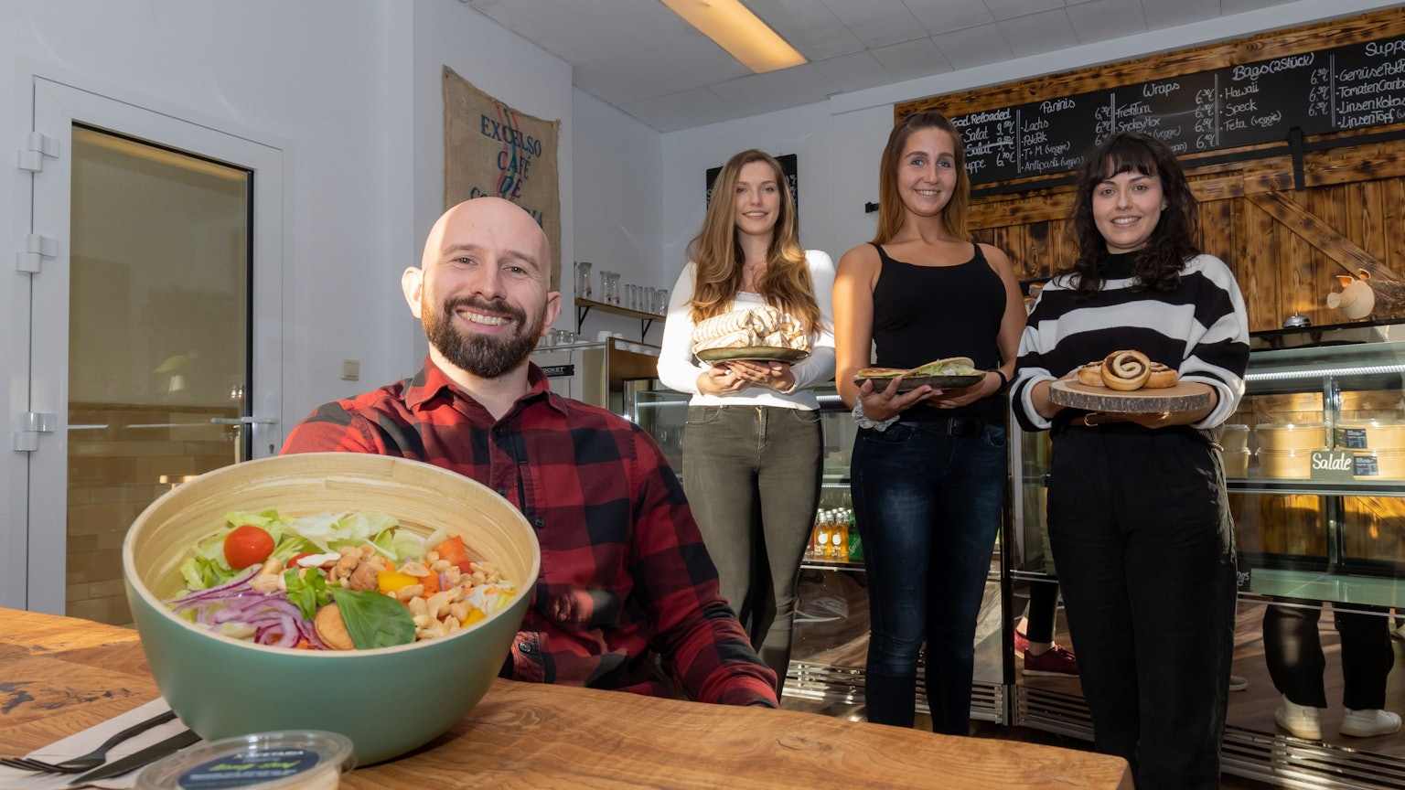 Gastronom Andreas Dauns und seine Mitarbeiterinnen zeigen eine Bowl und andere Speisen aus der Acetaria.