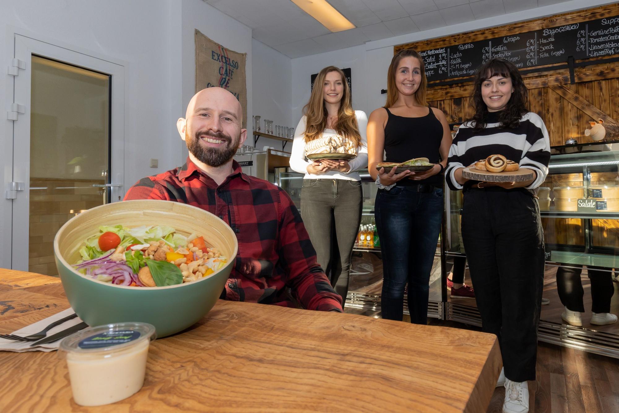 Gastronom Andreas Dauns und seine Mitarbeiterinnen zeigen eine Bowl und andere Speisen aus der Acetaria.