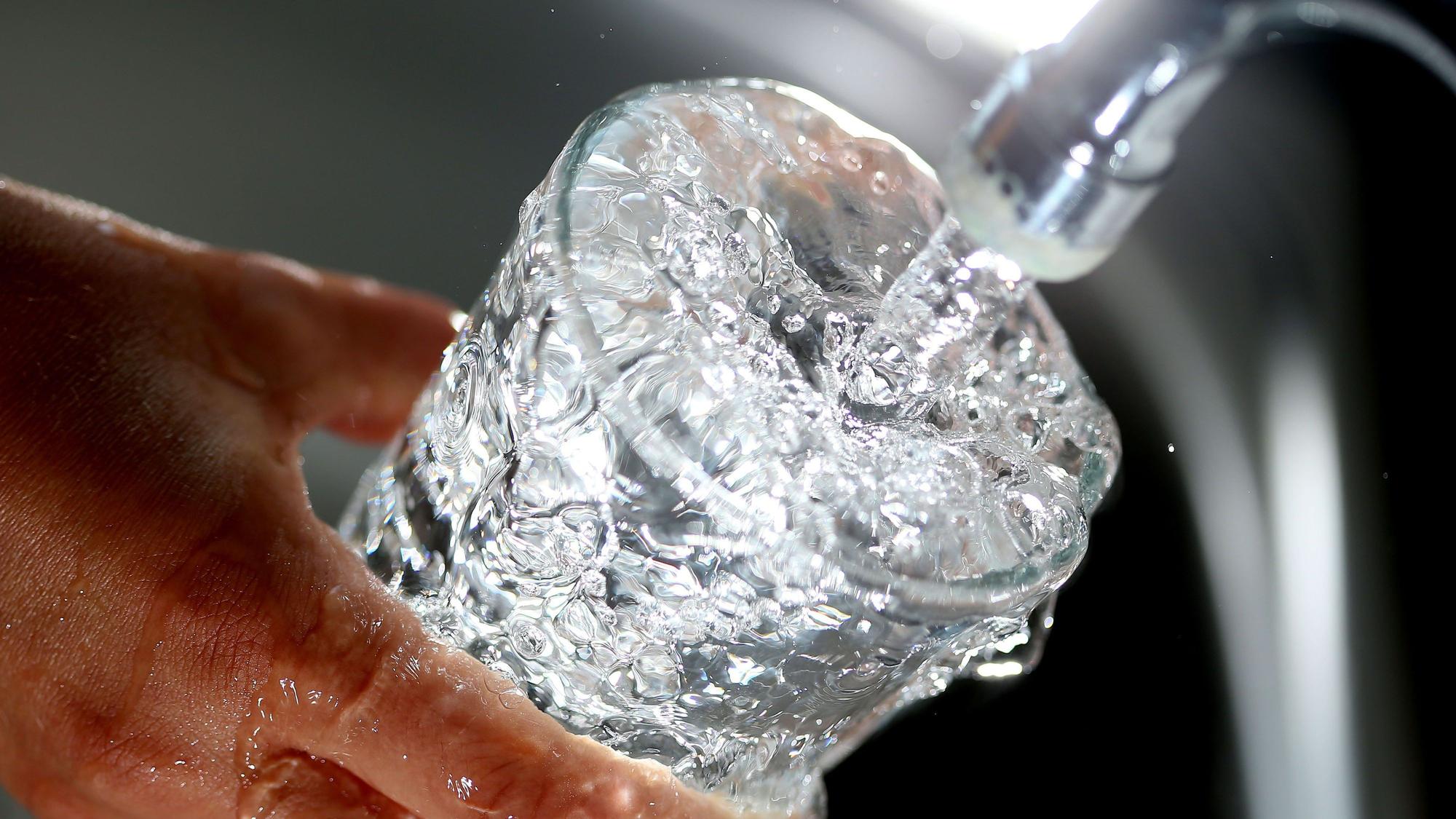 Symbolbild: Ein Glas wird mit Wasser gefüllt.