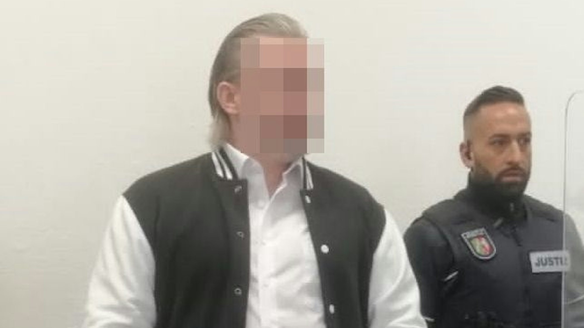 Von einem Justizmitarbeiter wird der angeklagte Hürther in den Gerichtssaal geführt. Der Mann wird beschuldigt, mehrere Frauen mit Thallium vergiftet zu haben.