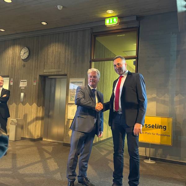 Olaf Krah (links) schüttelt seinem Kontrahenten Ralph Manzke die Hand. im Hintergrund ist ein Schild mit der Aufschrift „Wesseling“ zu sehen.