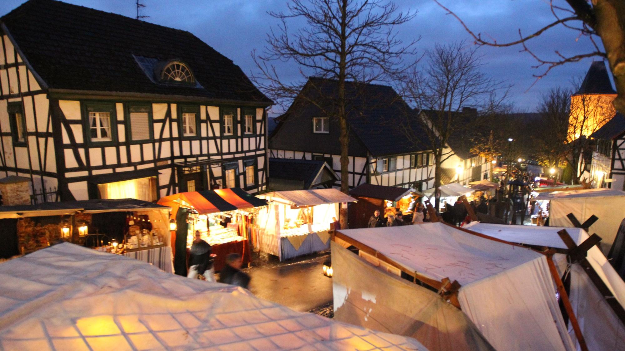 Verschiedene Marktstände stehen in der beleuchteten Innenstadt von Stadt Blankenberg.