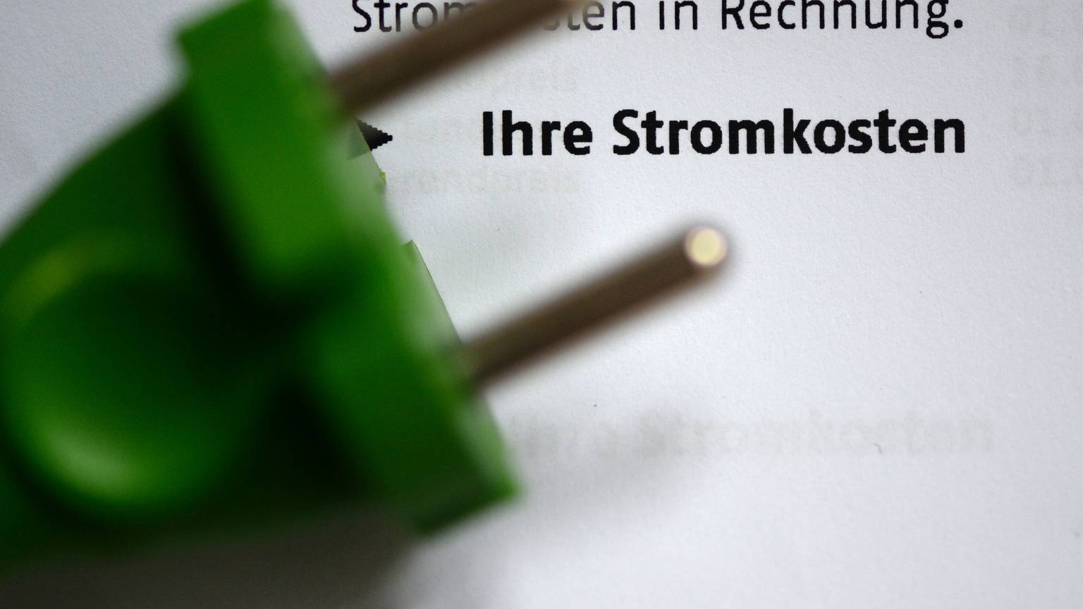 Ein grüner Stromstecker auf einer Stromrechnung.