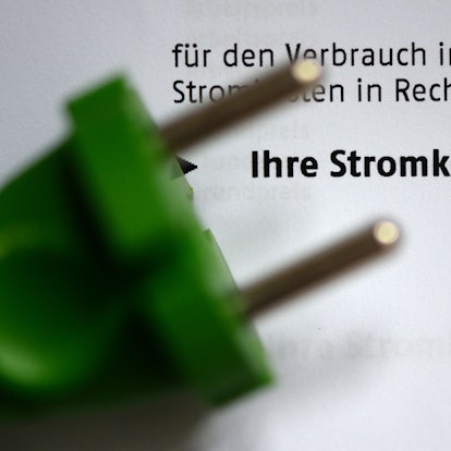 Ein grüner Stromstecker auf einer Stromrechnung.