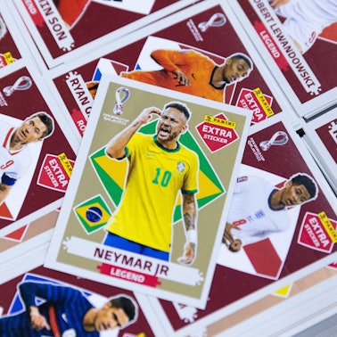 Sammelbildchen diverser Fußballer auf einem Stapel, obenauf „Neymar Jr.“ mit brasilianischer Flagge.