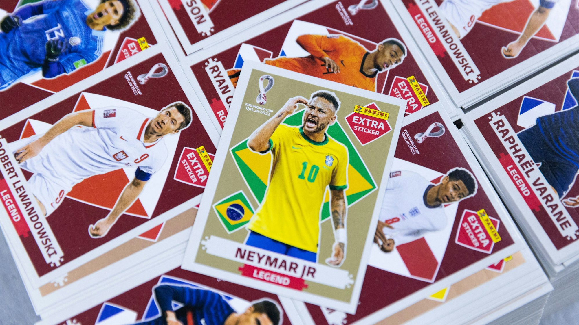 Sammelbildchen diverser Fußballer auf einem Stapel, obenauf „Neymar Jr.“ mit brasilianischer Flagge.