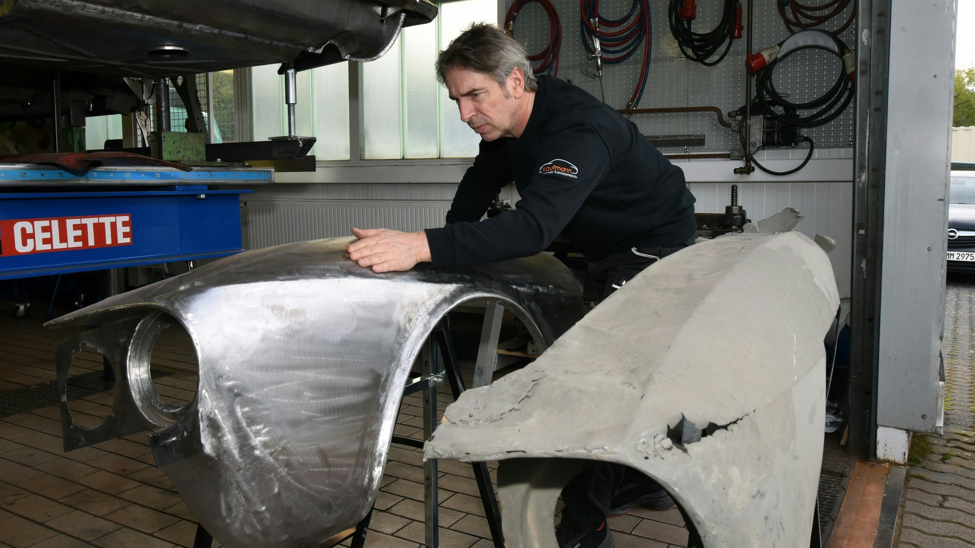 Peter Kaufmann steht neben Teilen der Auto-Karosse.