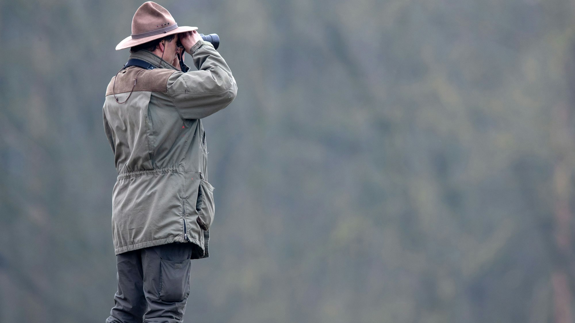 Ein Ranger schaut im Biosphärenreservatsamt Schaalsee-Elbe durch sein Fernglas.