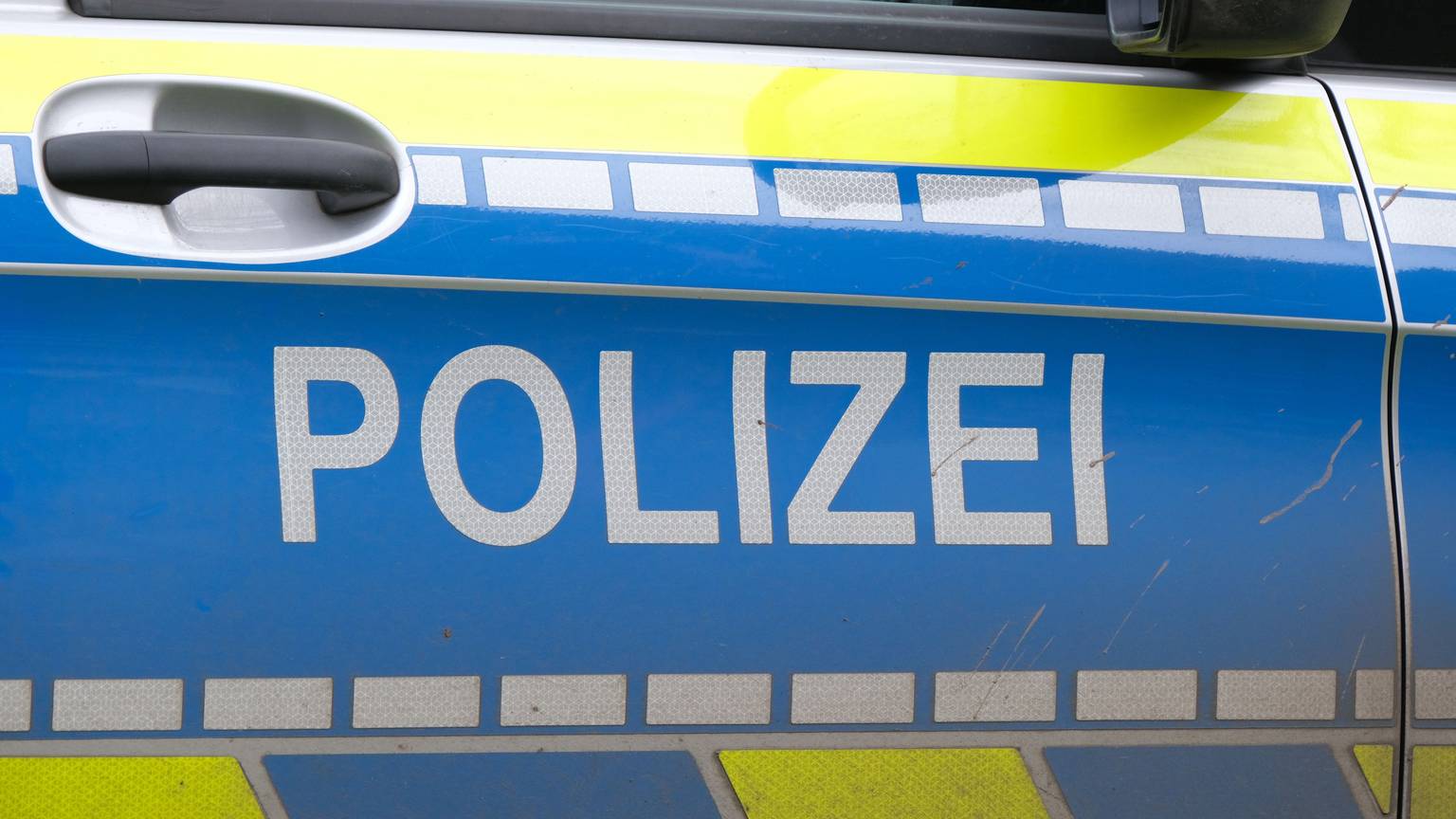 Wagentür eines Polizeiautos mit „Polizei“ Aufschrift (Symbolbild)