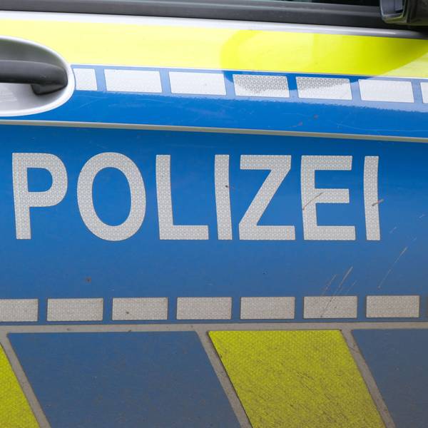Autotür eines Polizei-Fahrzeugs mit weißer Aufschrift „Polizei“ auf blau.