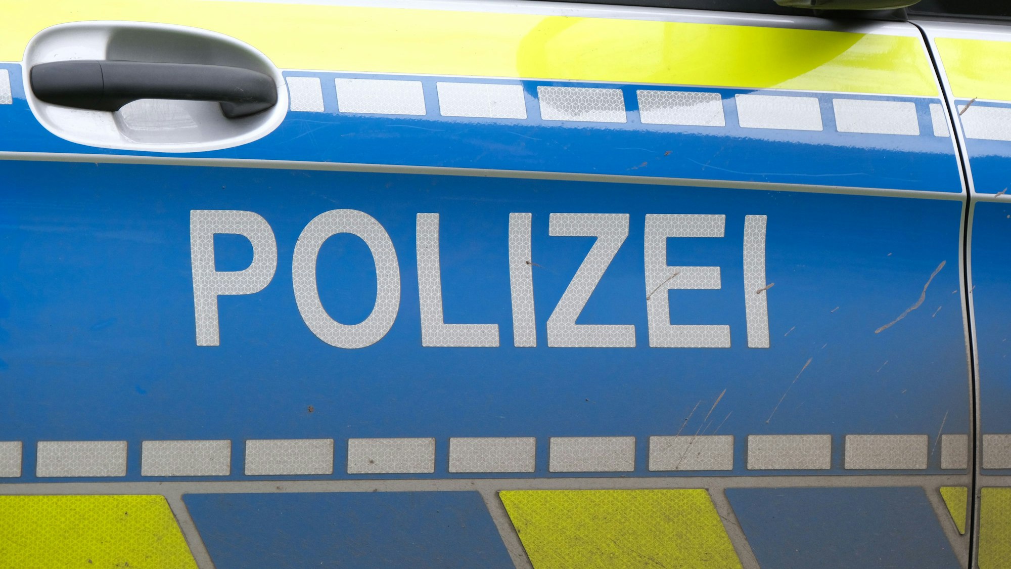 Autotür eines Polizeiwagens mit der Aufschrift „Polizei“ (Symbolbild)