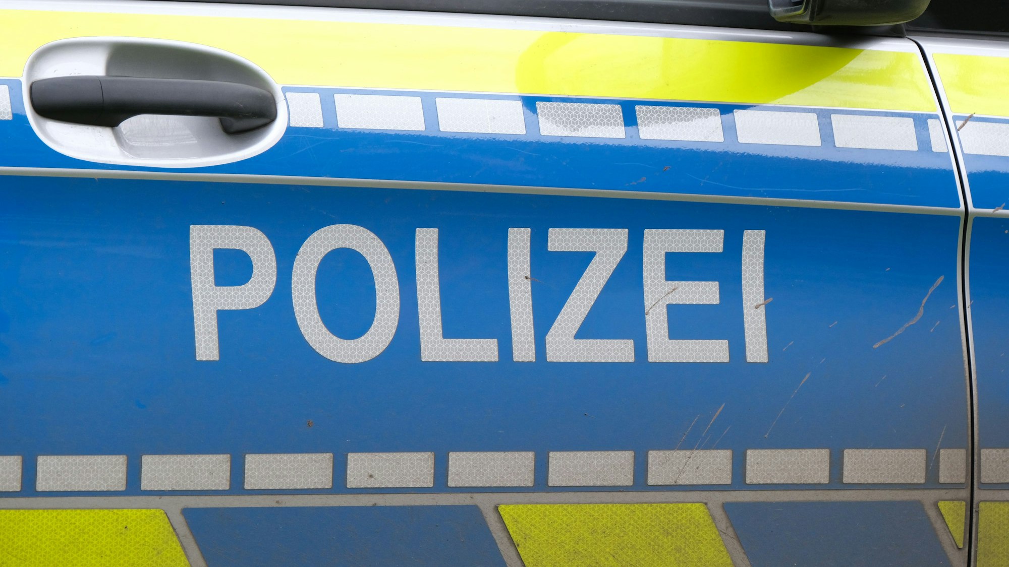 Der Polizeischriftzug auf einem Polizeiauto.