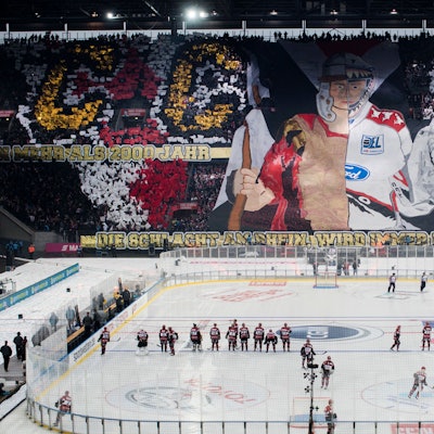 Das Rhein-Energie-Stadion während des Winter-Games 2019. Auf dem Platz sieht man die Mannschaften, auf den Rängen haben Fans eine Choreografie vorbereitet.