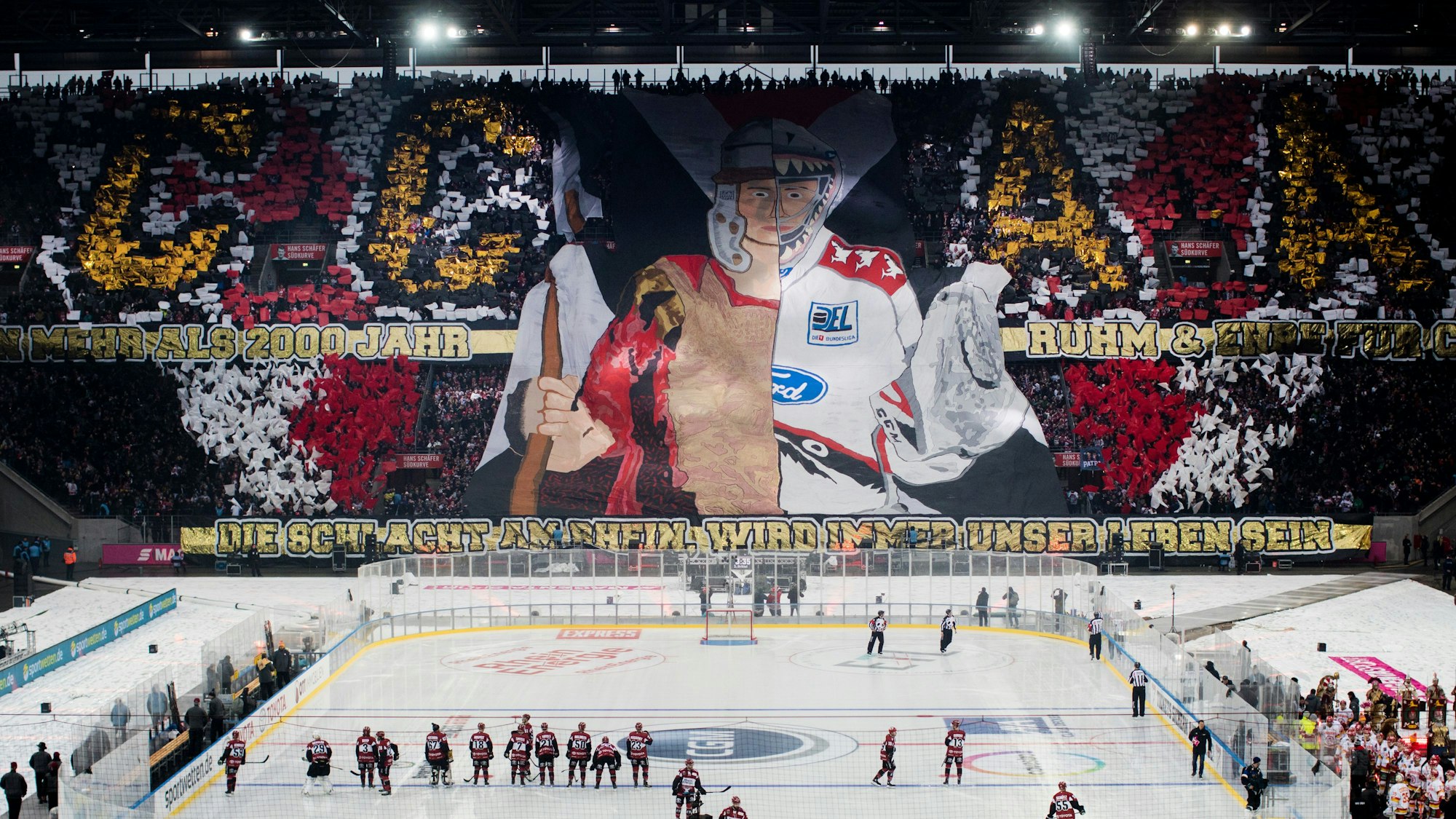Das Rhein-Energie-Stadion während des Winter-Games 2019. Auf dem Platz sieht man die Mannschaften, auf den Rängen haben Fans eine Choreografie vorbereitet.
