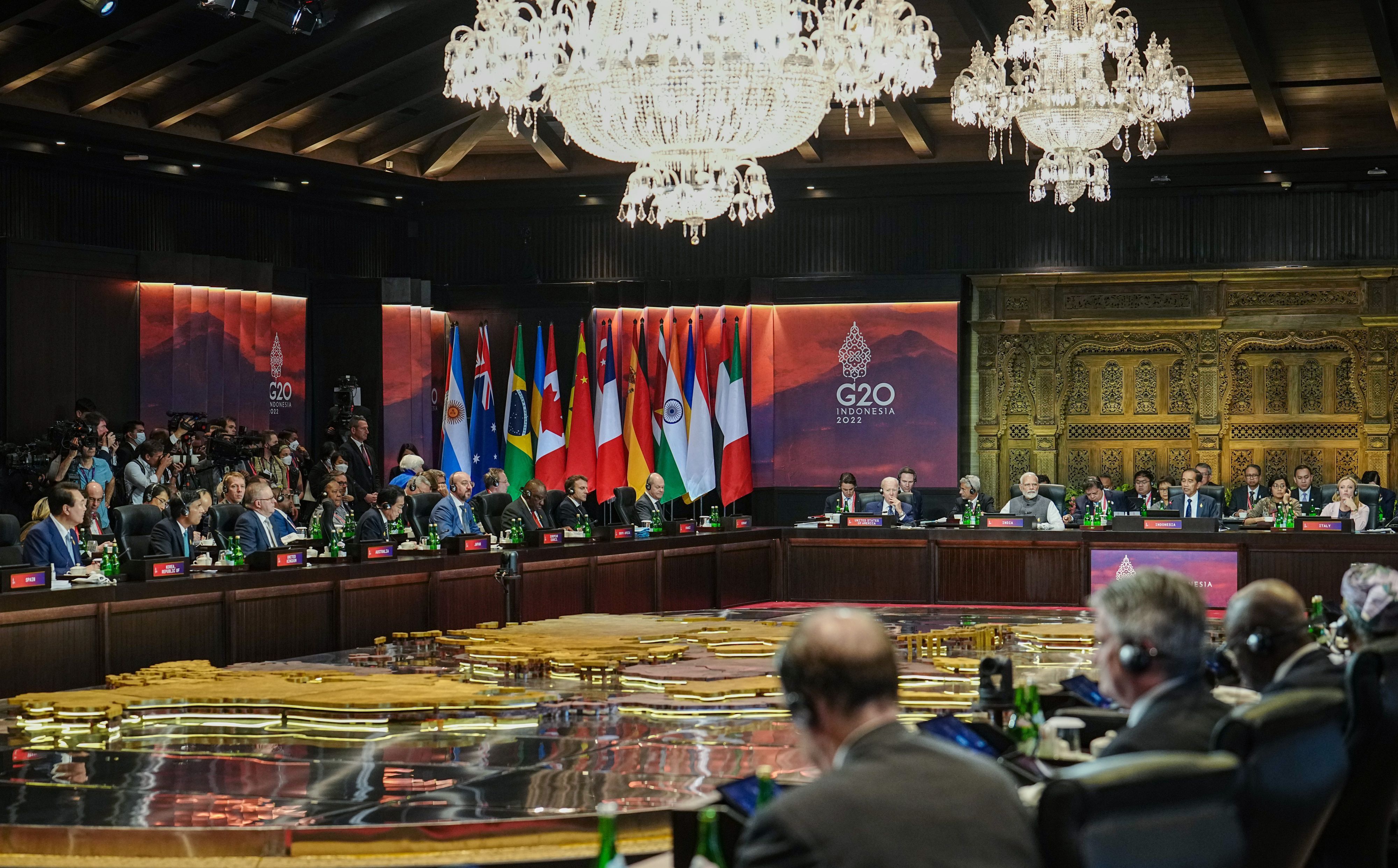 Regierungschefs der G20 nehmen an einer Sitzung teil. Sie sitzen sich an einem rechteckigen Tisch gegenüber.