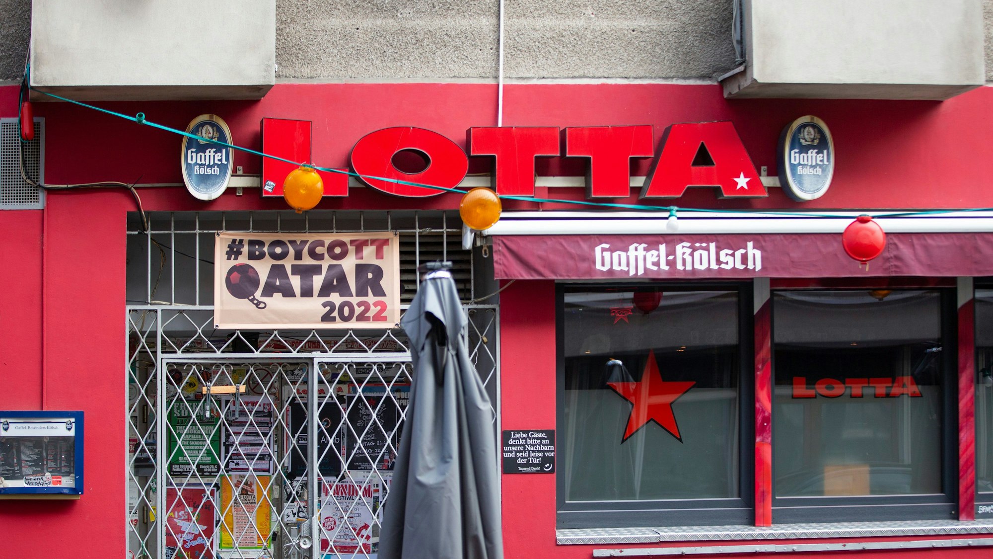 Über der Türschwelle der Kneipe Lotta hängt ein Banner mit der Aufschrift „Boykott Watar 2022“.