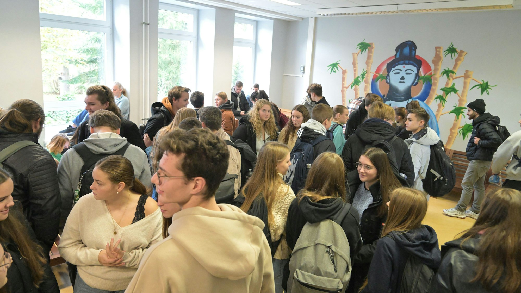 Viele Schülerinnen und Schüler stehen in einem Raum eng aneinander.