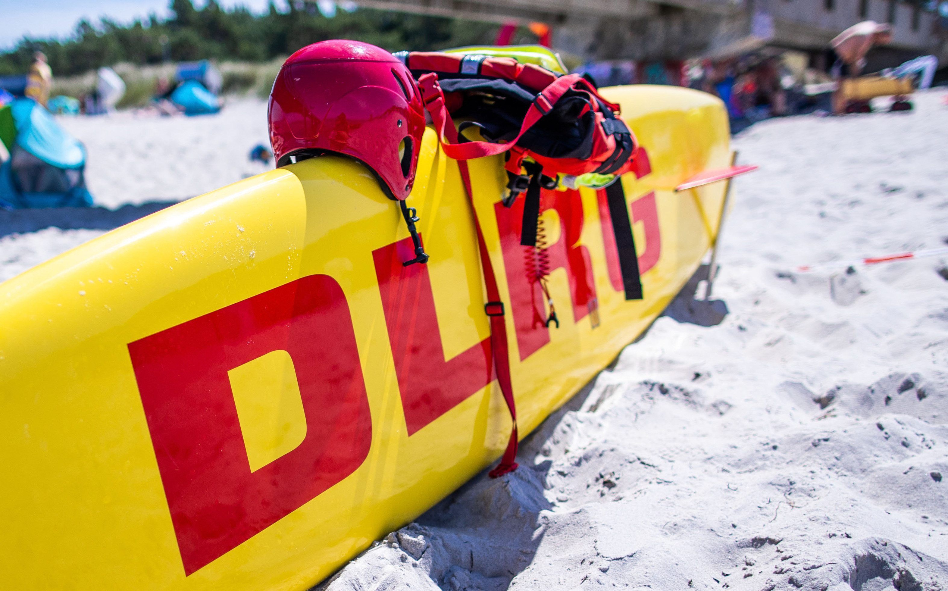 ARCHIV - 04.08.2022, Mecklenburg-Vorpommern, Prerow: Ein Rettungsboard der DLRG Wasserrettung steht einsatzbereit neben der Seebrücke an der Ostseeküste. Die Kölner Polizei ermittelt nach Angaben der Staatsanwaltschaft wegen sexueller Belästigung gegen einen Betreuer einer DLRG-Ferienfreizeit im vergangenen Sommer.
