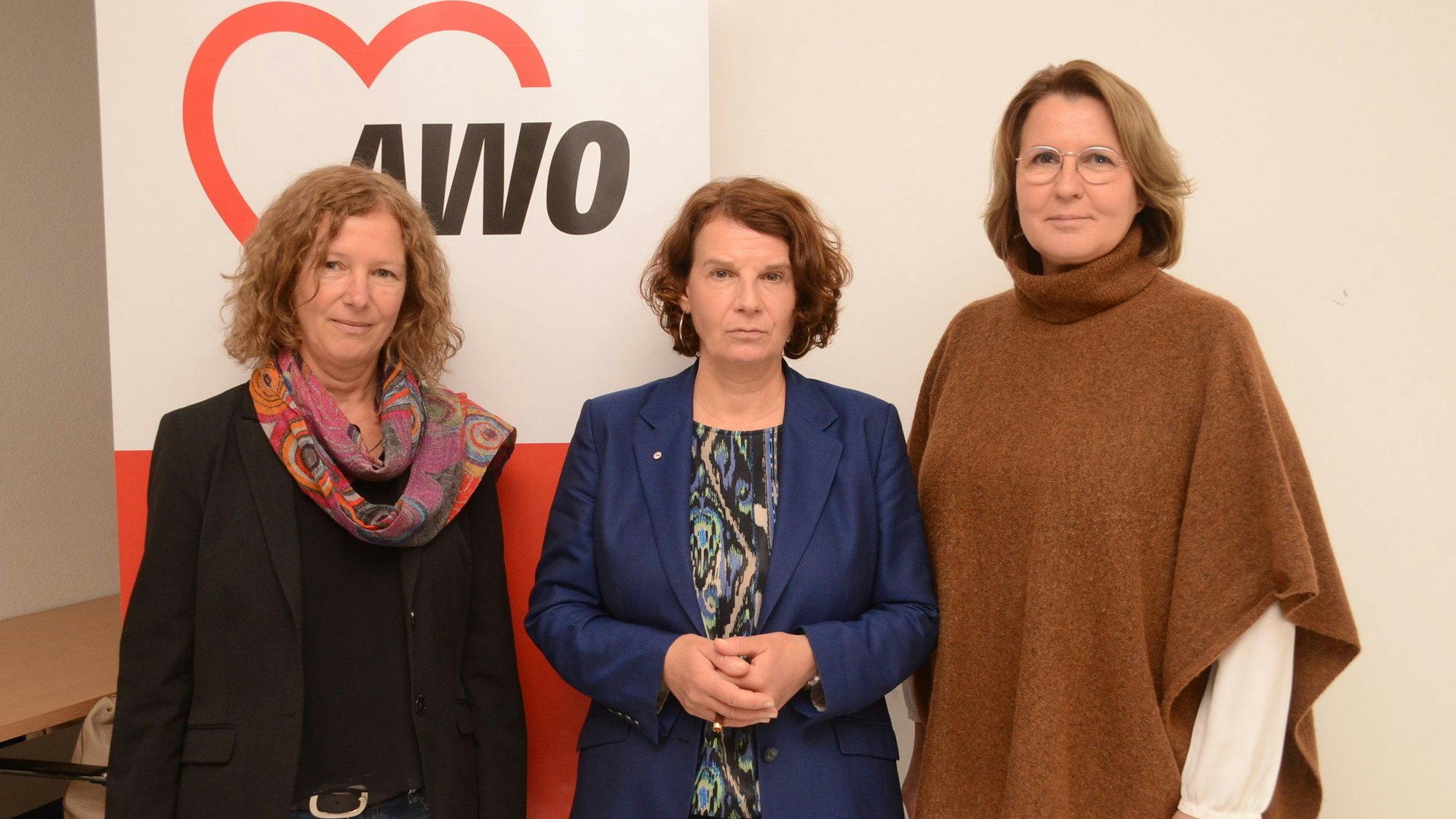 Die Awo-Mitarbeiterinnen Christiane Kaspari, Barbara König und Viera Lohrey stehen vor einem Aufsteller mit dem Logo der Awo.