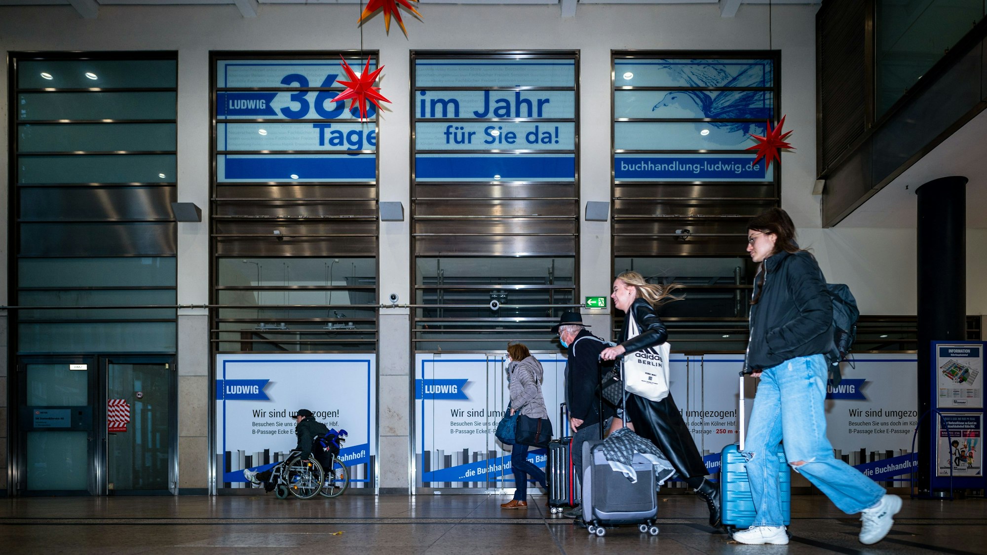 Leute gehen an der geschlossenen Buchhandlung im Hauptbahnhof vorbei.