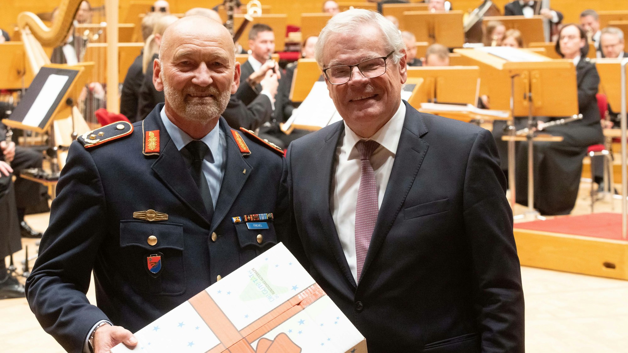 Paketübergabe beim Konzert mit dem Musikcorps der Bundeswehr für die Rundschau-Altenhilfe.