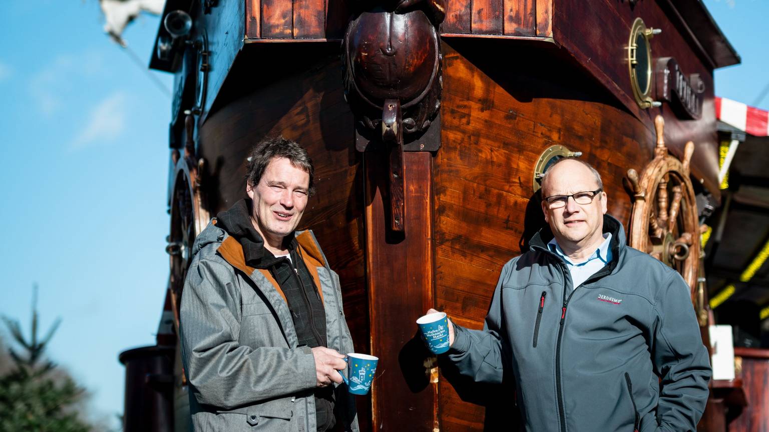 Hafen-Weihnachtsmarkt-Veranstalter Edwin Kroll (l.) und Klaus Schopen vom Schokoladenmuseum stehen vor einem Schiff im Kölner Weihnachtsmarkt am Schokomuseum.
