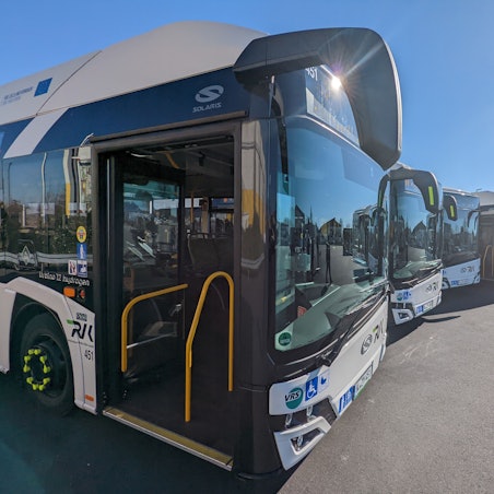Fünf neue Wasserstoffbusse vom Typ Solaris stehen auf einem Parkplatz.