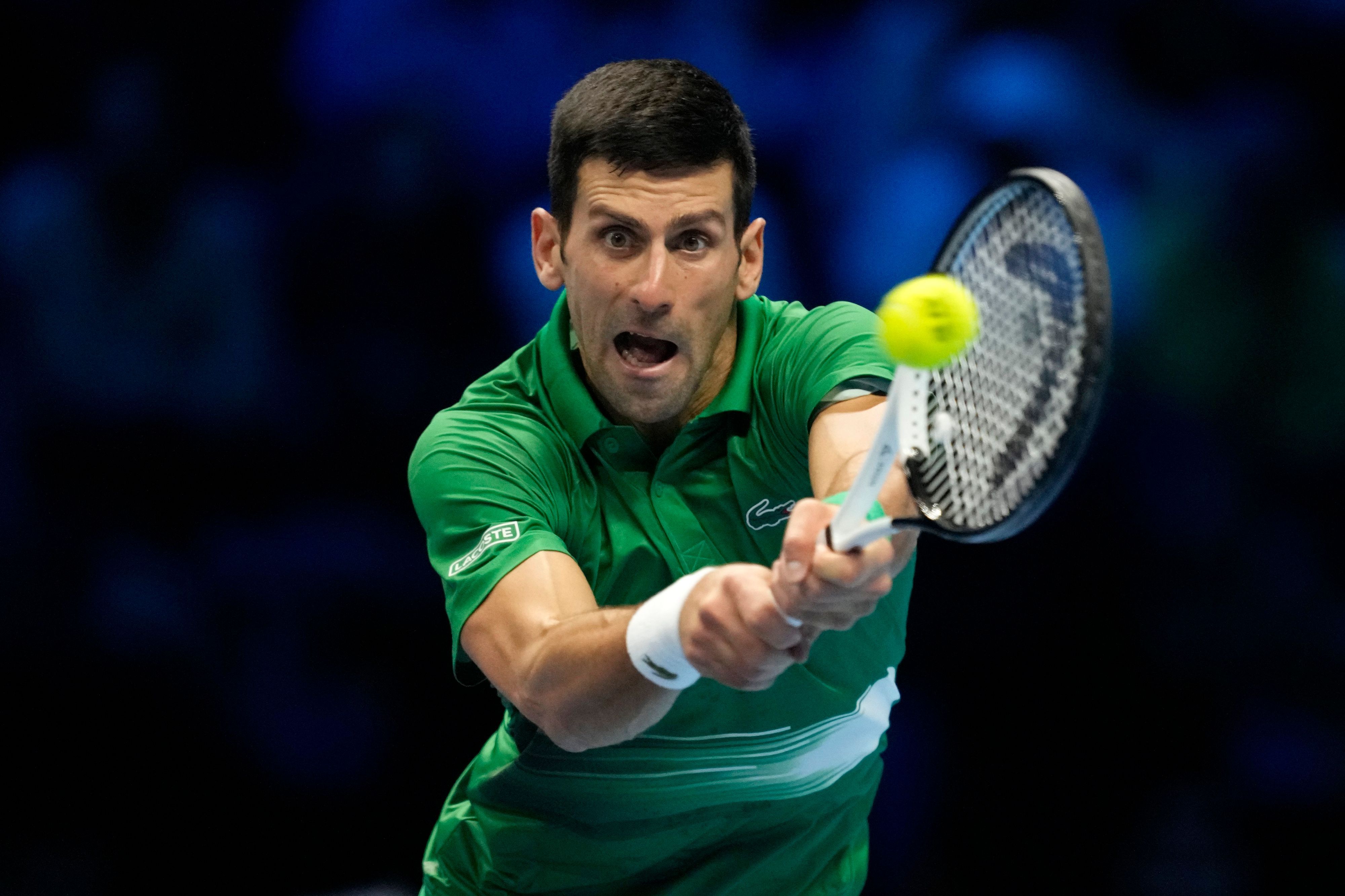 Novak Djokovic schlägt mit seinem Tennisschläger einen Ball.