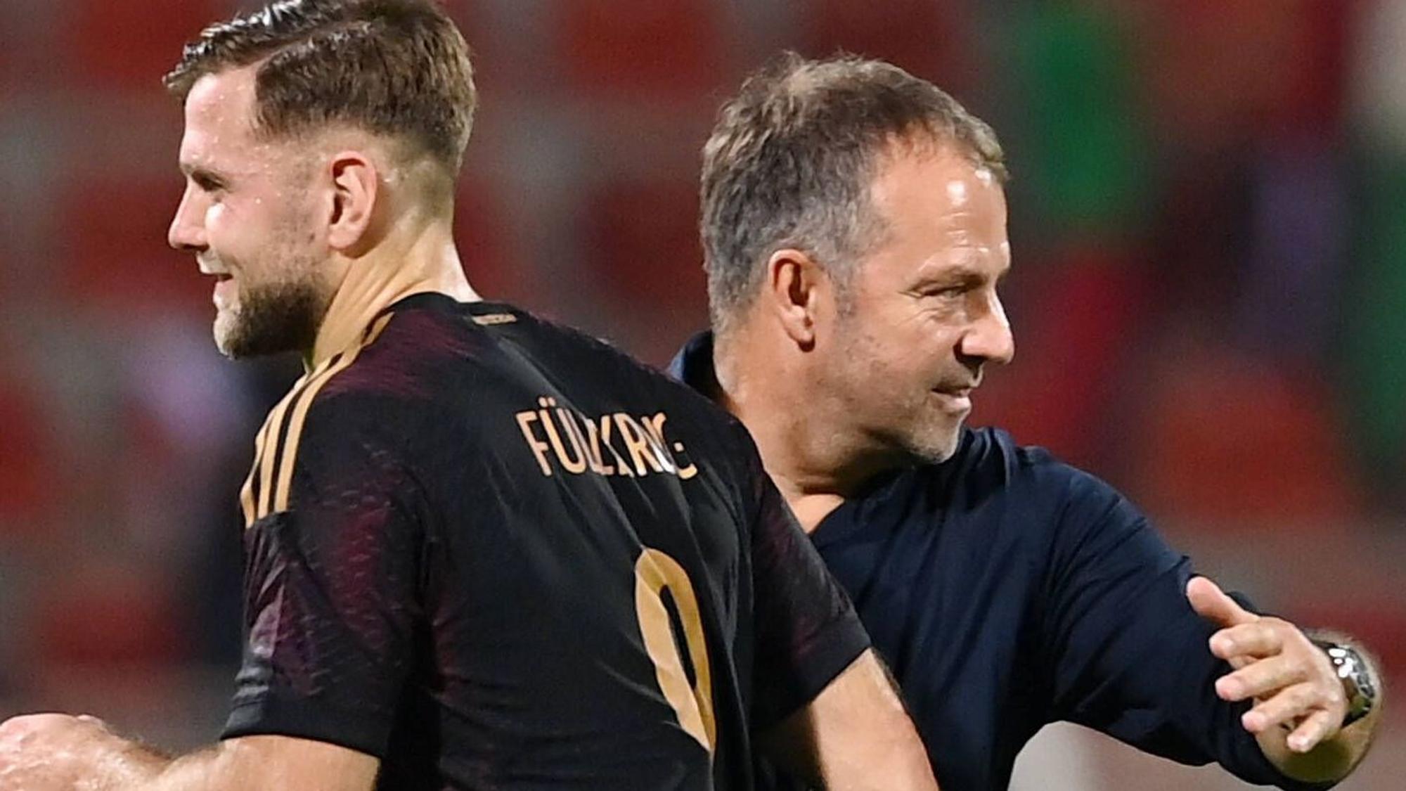 Bundestrainer Hansi Flick klatscht nach dem Spiel mit Torschütze Niklas Füllkrug ab.