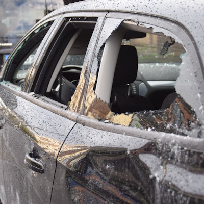 Ein gegenüber der Filiale abgestellter Pkw mit zerstörten Scheiben und Dellen.