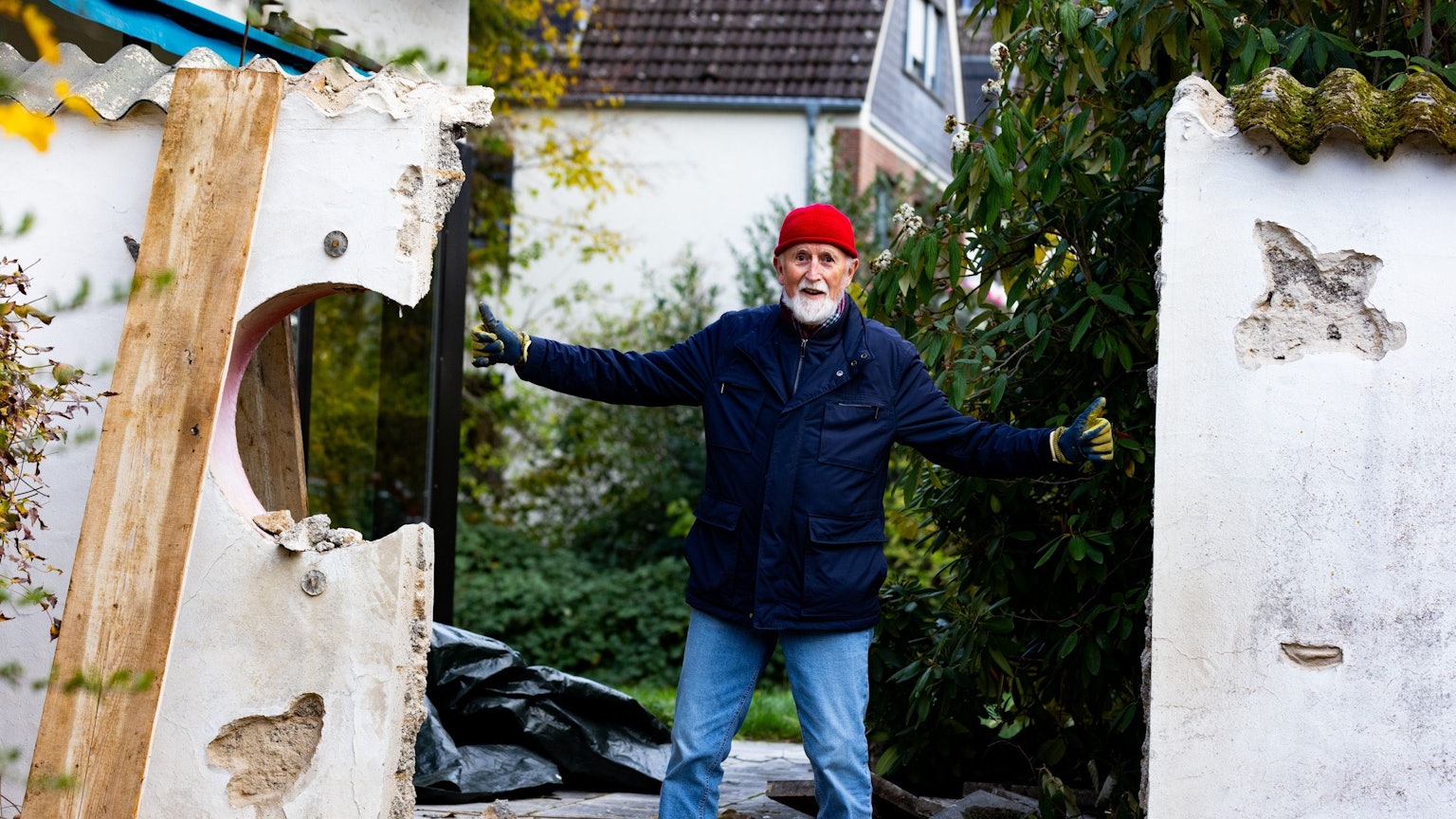 Der 74 Jahre alte Peter-Josef Münz steht mit ausgestreckten Armen in der Mauerlücke, wo sich das Relief befand.