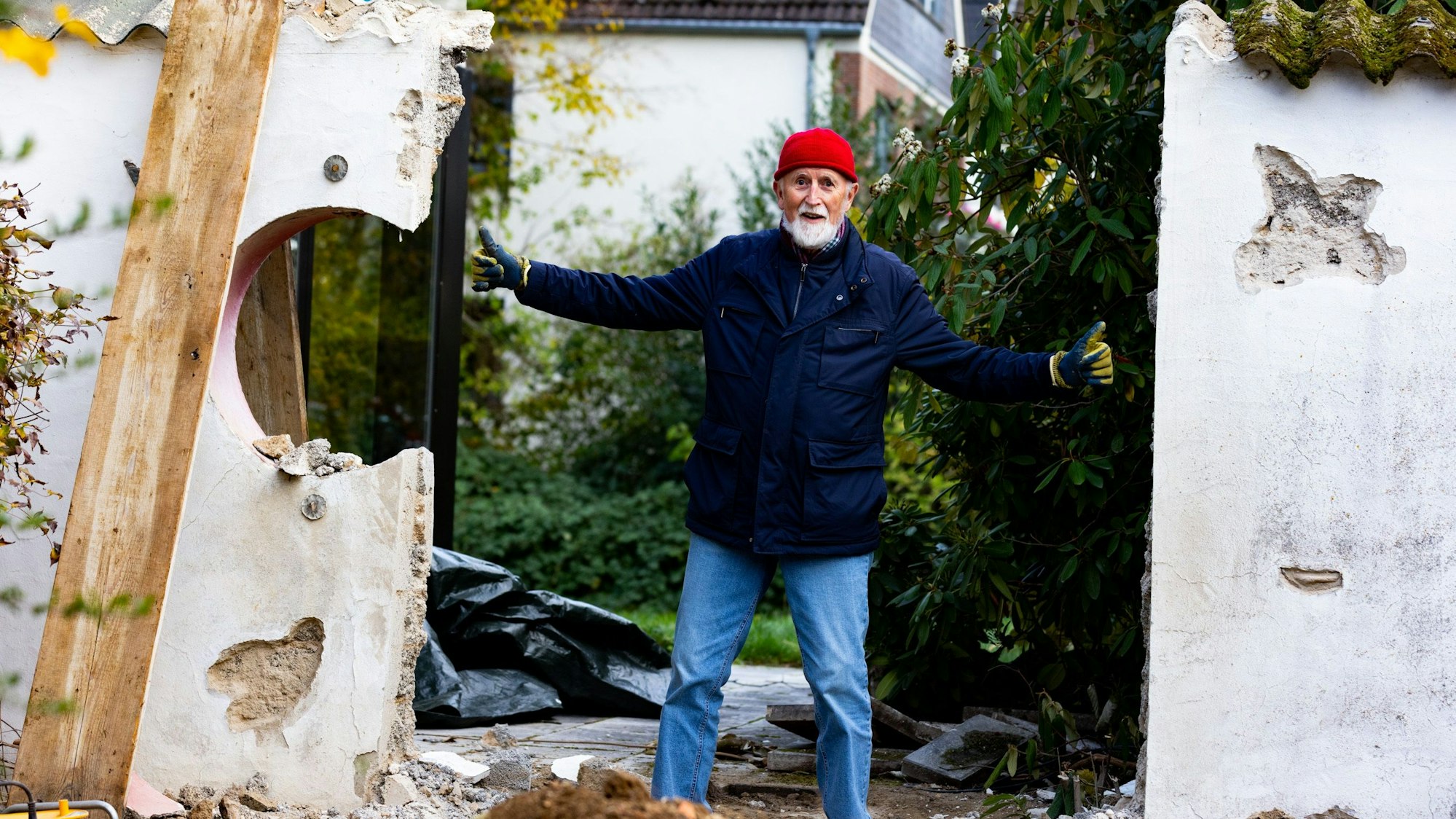 Der 74 Jahre alte Peter-Josef Münz steht mit ausgestreckten Armen in der Mauerlücke, wo sich das Relief befand.