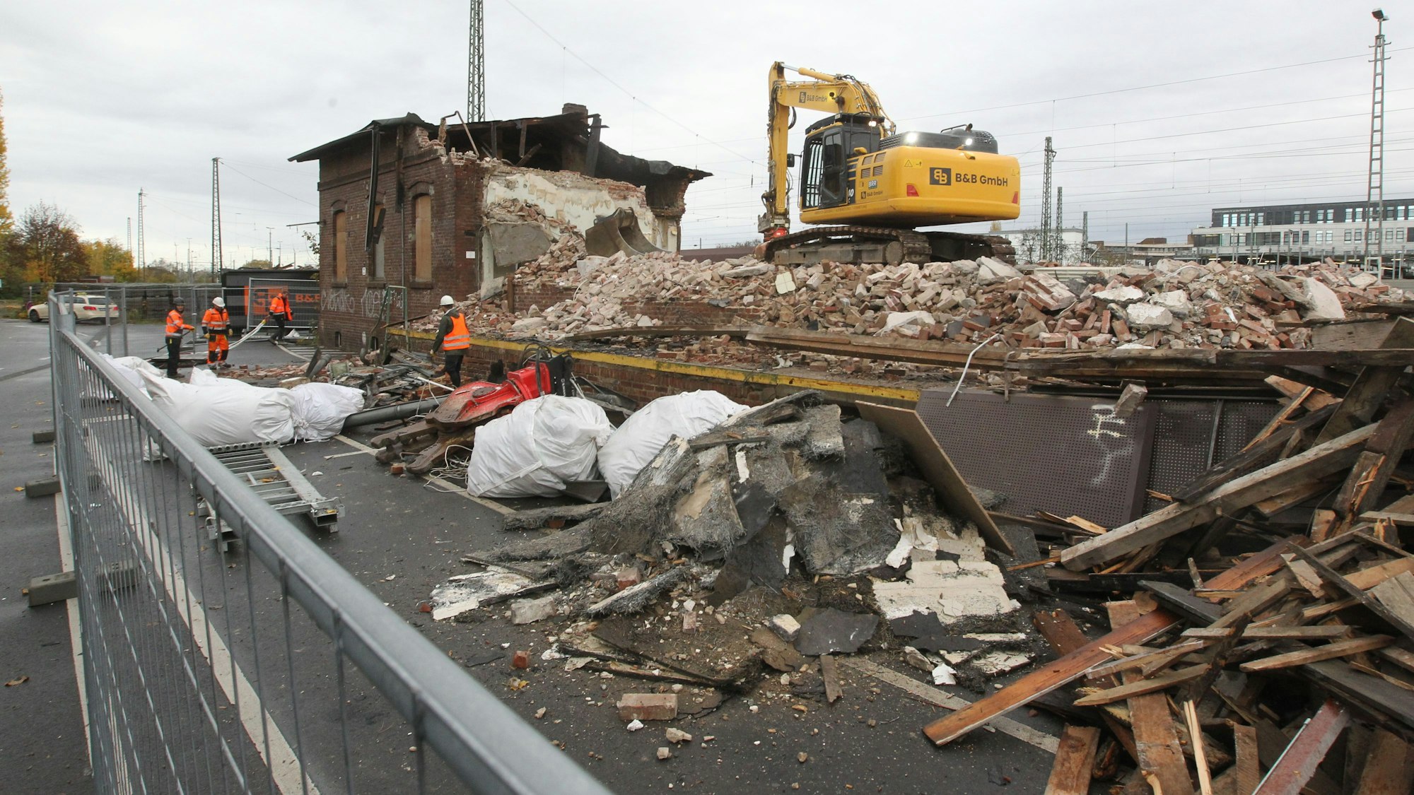 Das Haus am Güterbahnhof Troisdorf liegt zum großen Teil in Trümmern. Ein Bagger arbeitet auf dem Schutthaufen.