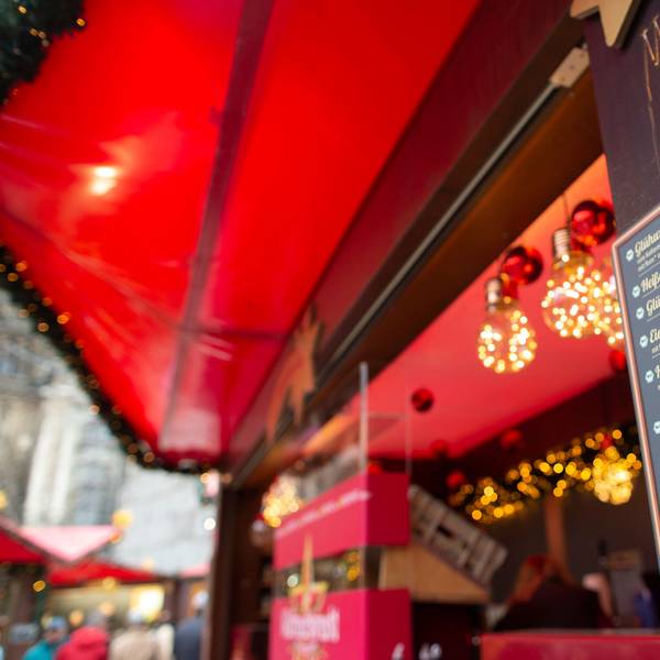 Auf einer Preistafel auf dem Weihnachtsmarkt auf dem Roncalliplatz stehen Preise für Glühwein und Co.
