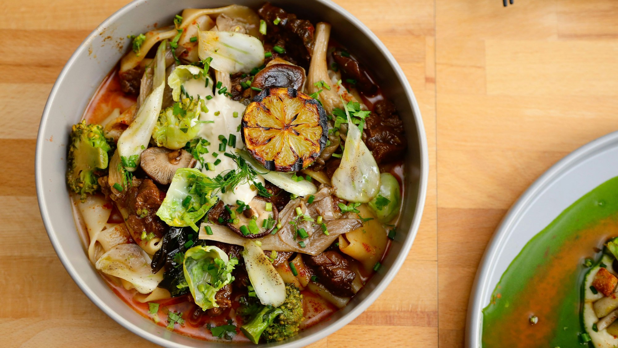 Hausgemachte Bandnudeln mit sanft geschmorten Rindfleisch und pikantem asiatischen Gemüse und Pilzen.