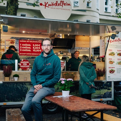 Christoph Schrader sitzt vor seinem Knödelfein-Foodtruck auf dem Kölner Rudolfplatz.