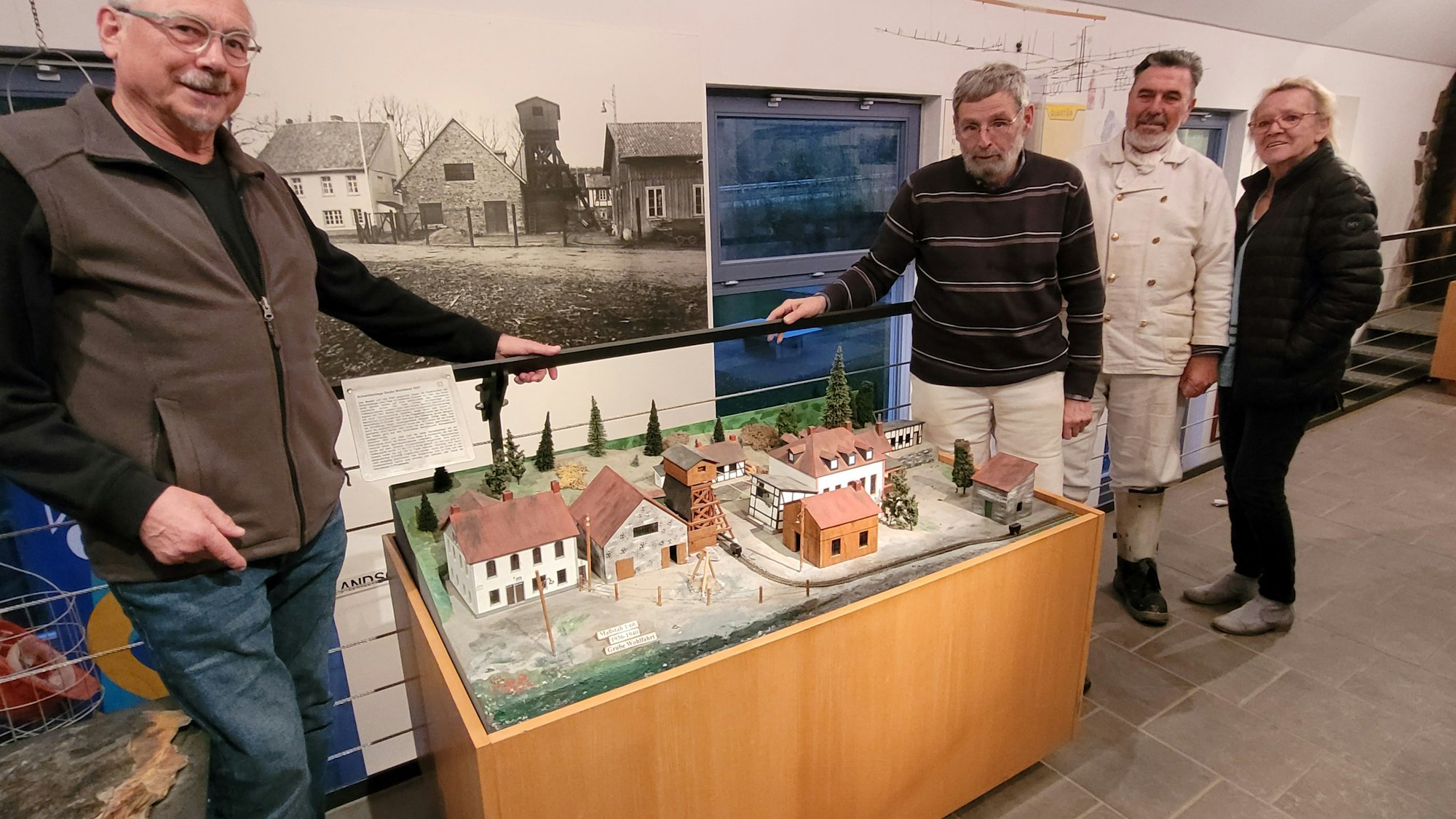 Vier Menschen stehen um ein Städtemodell herum.