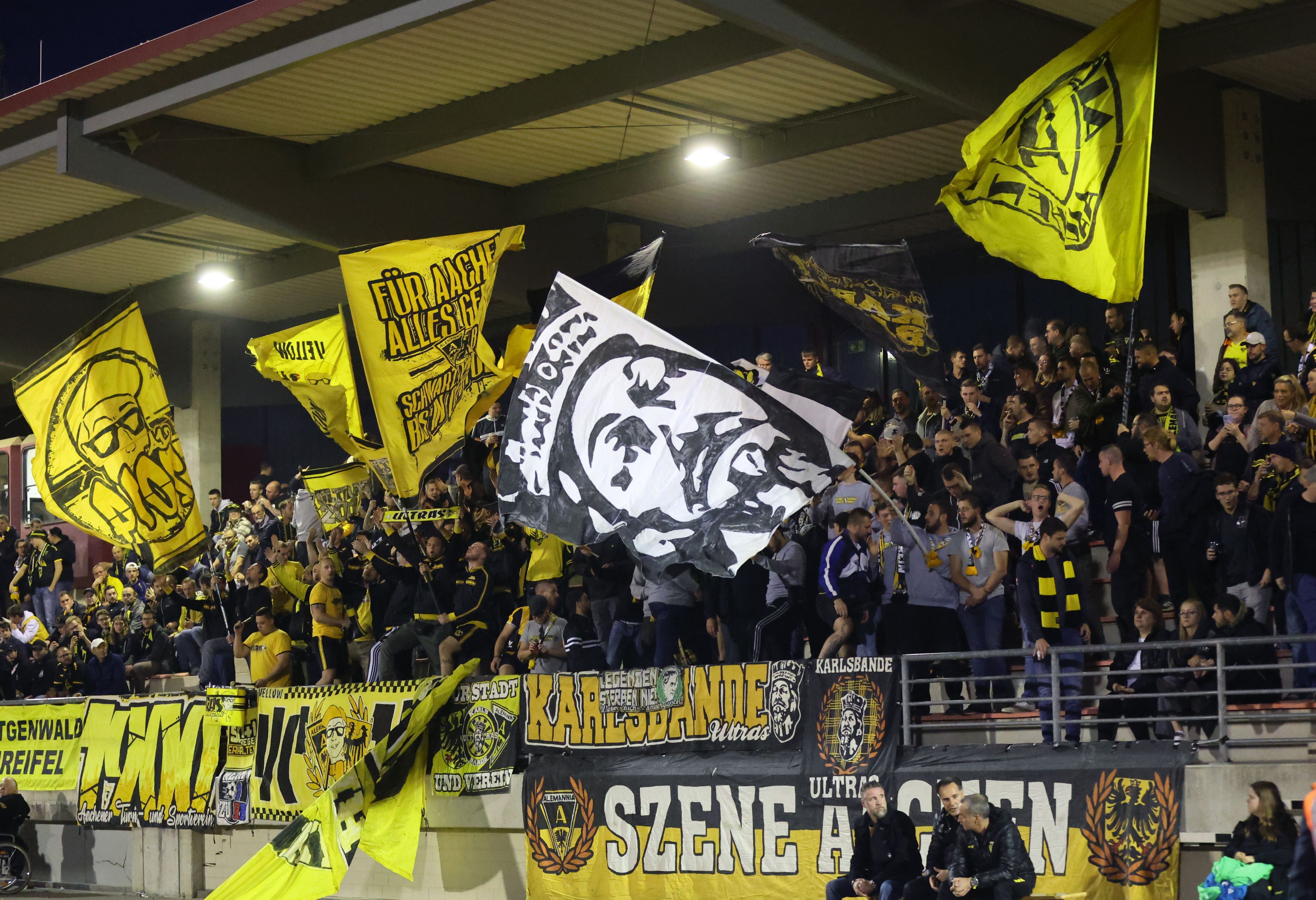 Menschenmenge im Stadion schwingt gelbe Fahnen.