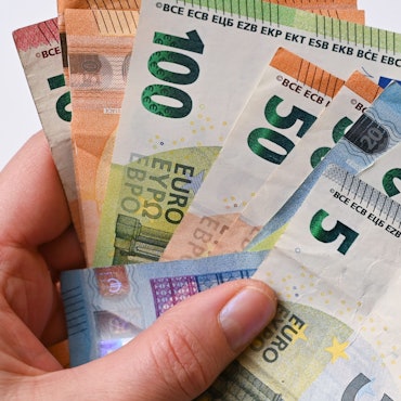 Eine Frau hält Eurobanknoten in ihren Händen (gestellte Aufnahme).