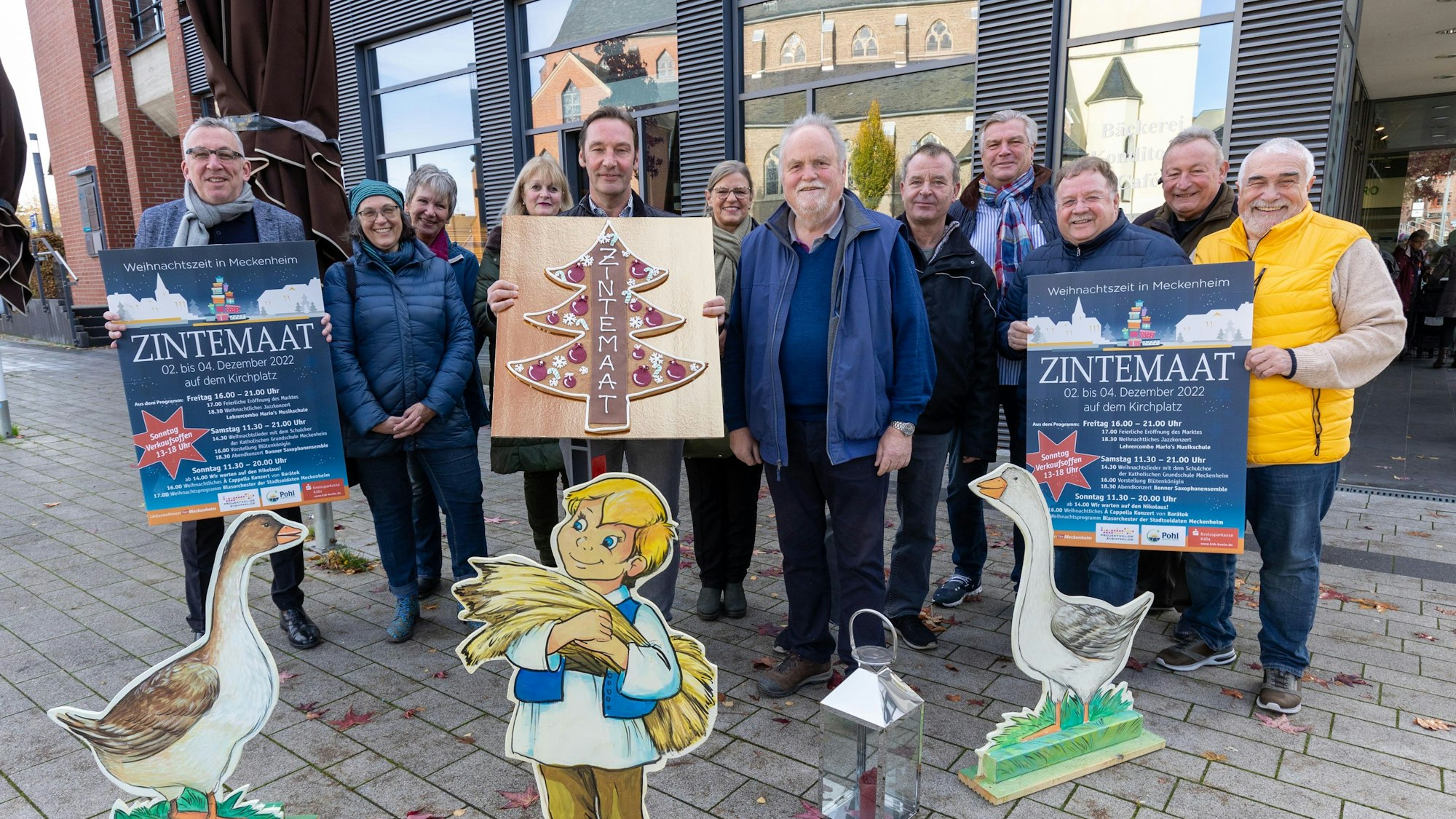 Vertreter des Verbunds, der Stadt und der Bäckerei Mauel zeigen Plakate.