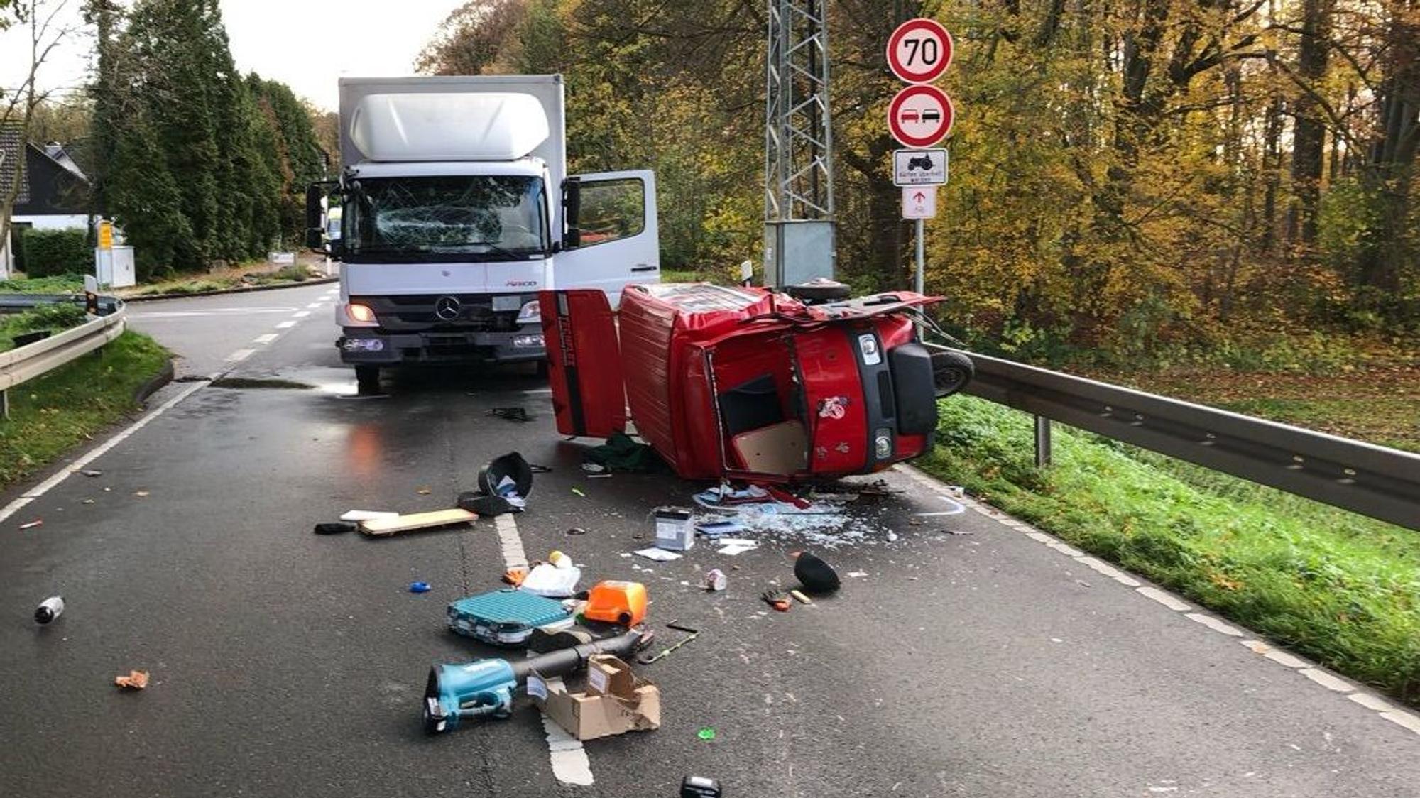 Auf der Straße liegen Trümmerteil und ein umgekipptes dreirädriges Leichtkraftrad. Im Hintergrund steht ein Lkw.