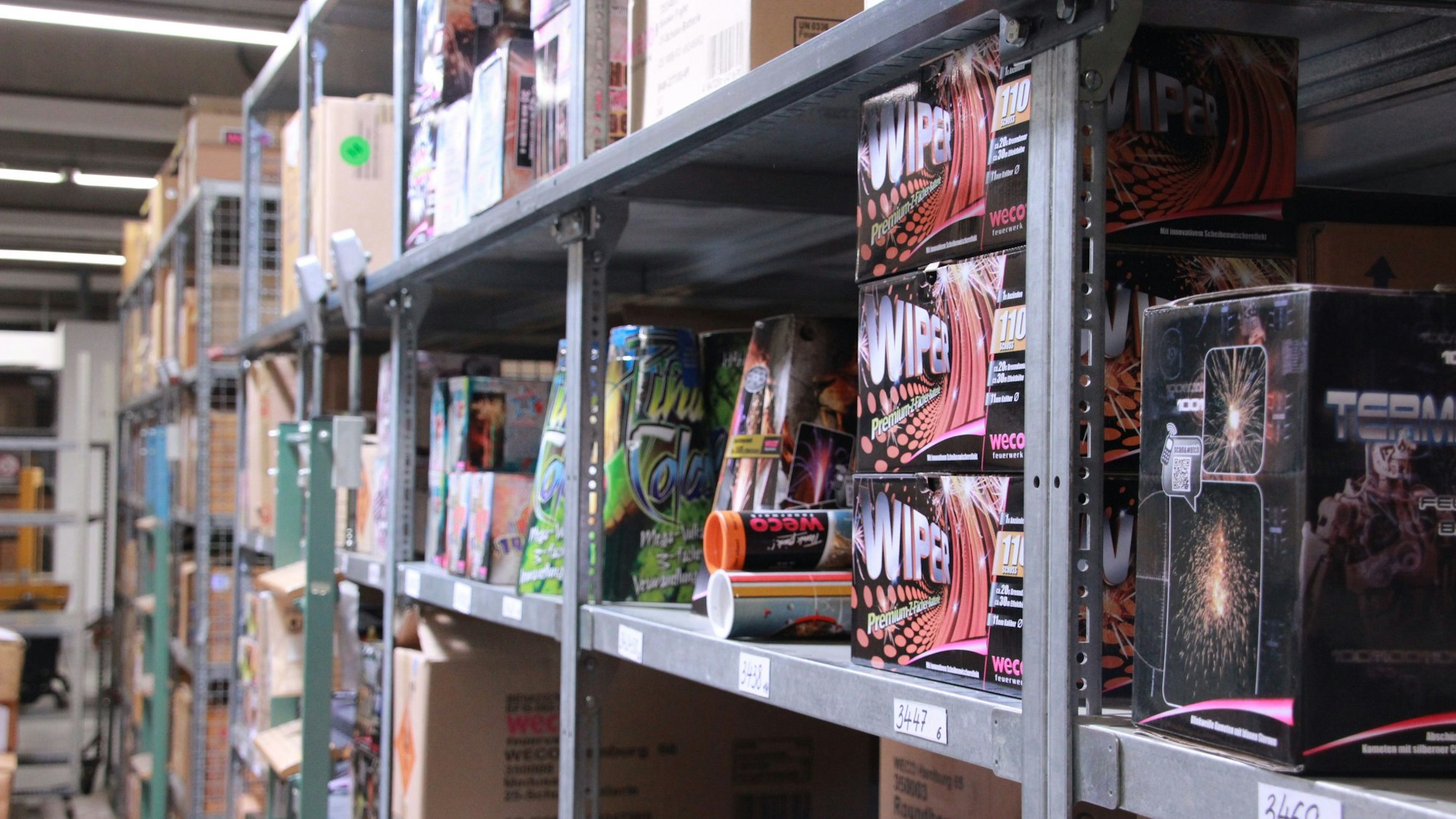 Auf Regalen stehen verschiedene Pakte mit Feuerwerkskörpern.