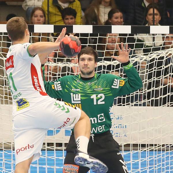 Ein Handballer wird einen Bal aufs Tor, in dem Daniel Rebmann mit grünem Trikot steht.