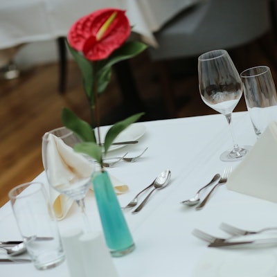 Ein eingedeckter Tisch wartet in einem Restaurant auf Gäste.