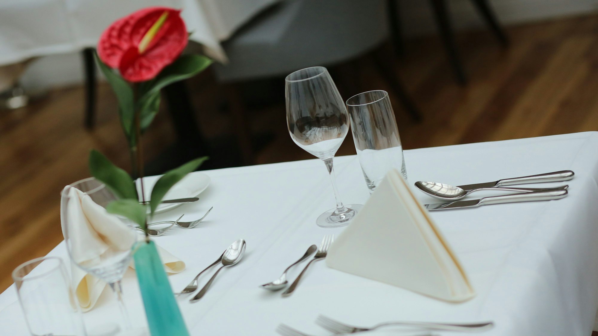 Ein eingedeckter Tisch wartet in einem Restaurant auf Gäste.